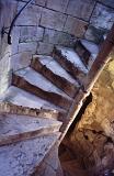 Spiral staircase in an old stone tower interior winding their way upwards