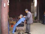 Old Professional Chinese Barber with Old Male Customer at Vintage Barber Shop in China.