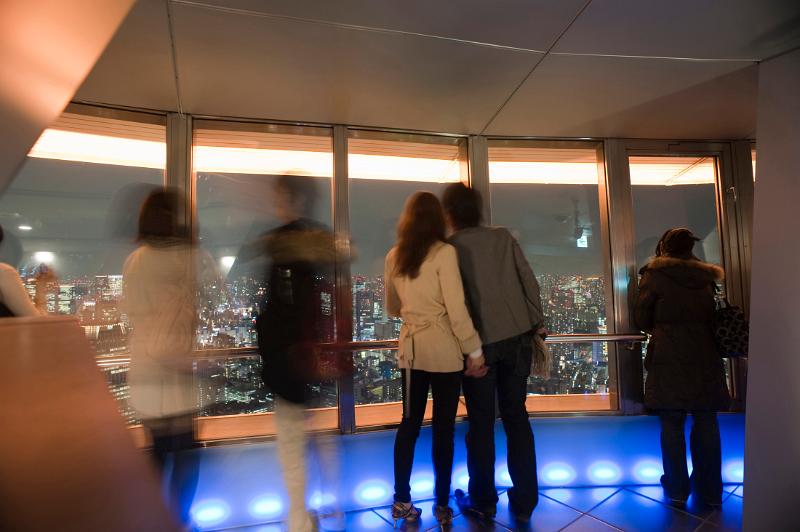 visitors enjoying the view from the top of the tokyo tv tower at night  - not model released