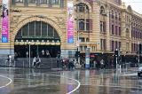 Flinders Street, Melbourne, Australia in the rain with the arched entrance to the station across the street
