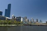 View of Melbourne Southbank and the CBD over the calm water of the Yarra River with a bridge in the foreground on a sunny day