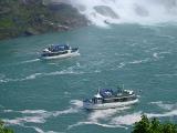 Tourist boats at the foot of the Maid of the Mist Niagara Falls between Canada and the USA with the spray from the waterfall visible in the background