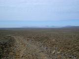 Iceland Path on Wide Brown Field Isolated on Light Blue Sky Background.