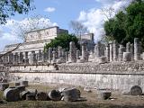 View of the stonework at the Chitzen Itza Mayan ruins with fallen stone, rows of columns and the Temple of the Warriors in the background, Yucatan Peninsula, Mexico