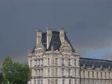 Paris rainbow in a rainy stormy grey sky behind an imposing historical urban stone building