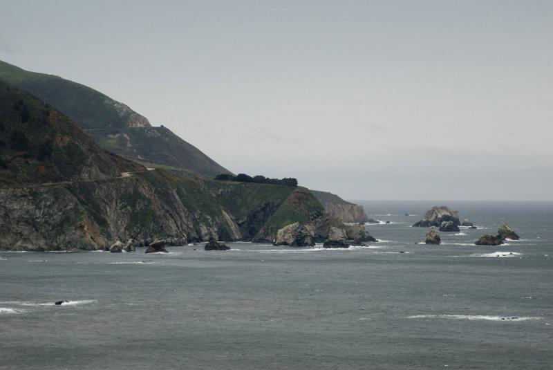 Big Sur coast, California on a grey overcast rainy day with a rocky headland jutting out into a calm ocean