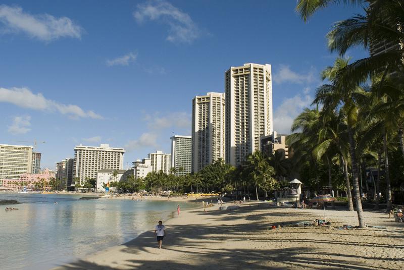Scenic view of Waikiki Beach, Hawaii with its golden sand, palm trees and high-rise apartment blocks overlooking the bay