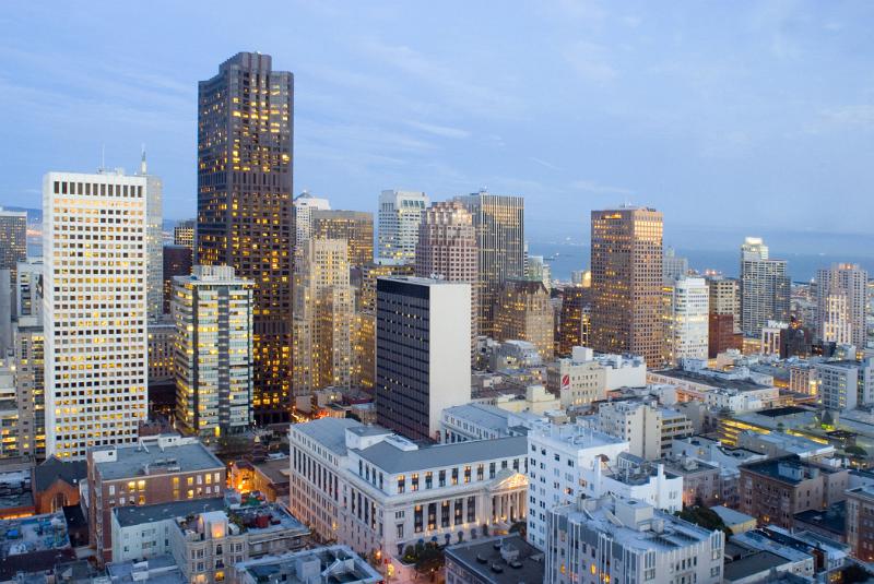 Sunset cityscape of San Francisco, California at twilight showing the lights beginning to glow in the modern skyscrapers and highrise buildings