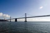 Low angle view across the water of the San Francisco Bay Bridge , a landmark suspension road bridge crossing the bay