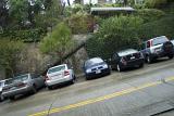 Cars parked side by side on a steep hill in San Francisco showing the steepness of the gradient on the streets leading down to the bay