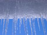 Close up Snow and Icicles on Light Blue Sky Background During Winter Season.